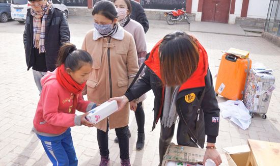 图7 志愿者为孩子们发放爱心物资.jpg